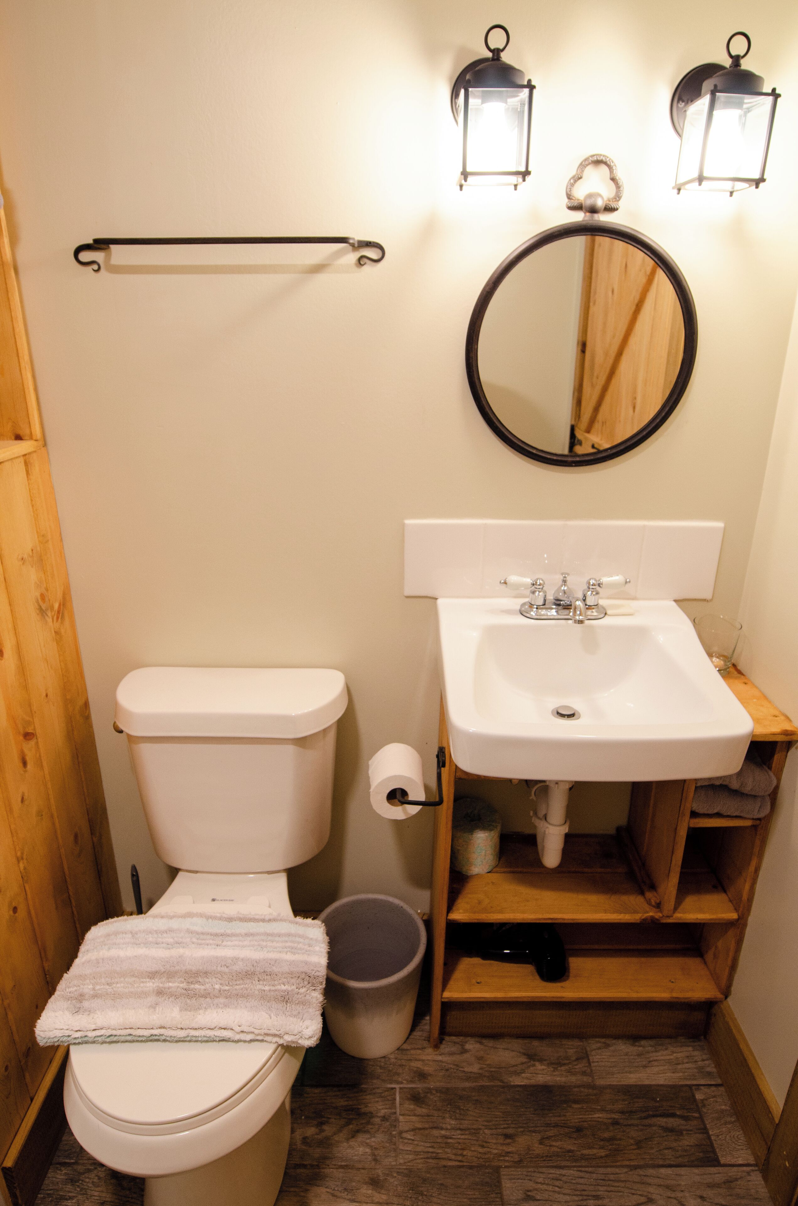 A compact bathroom with a toilet, sink, and mirror.