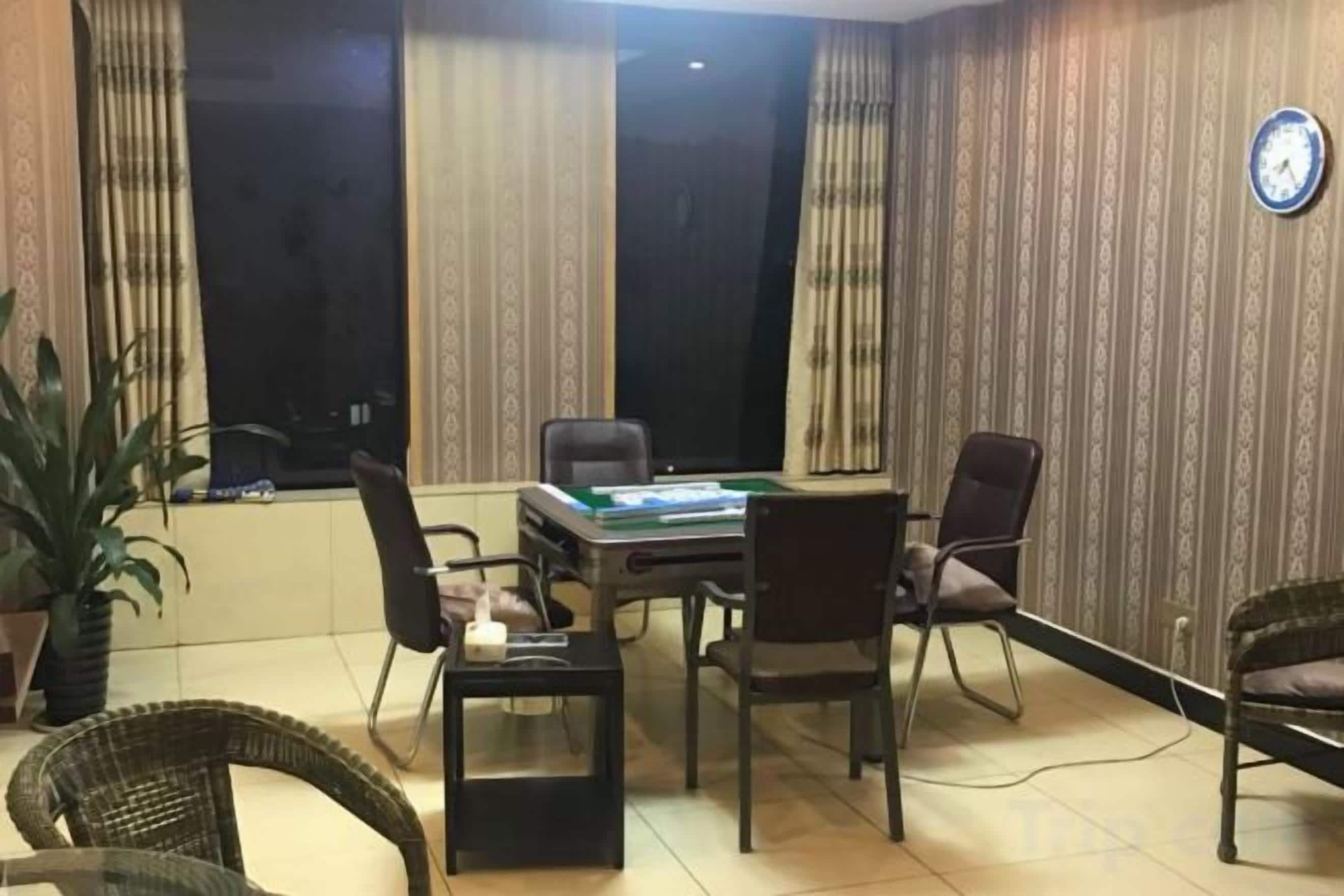Una sala de conferencias con una mesa, sillas y un reloj en la pared.