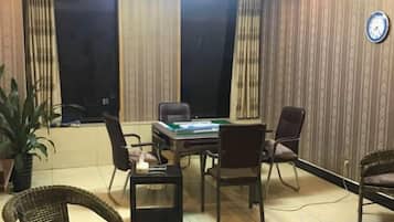 Una sala de conferencias con una mesa, sillas y un reloj en la pared.