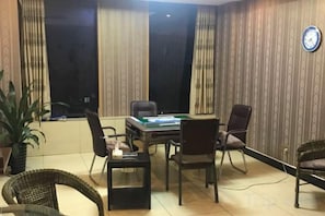 Une salle de conférence avec une table, des chaises et une horloge au mur.