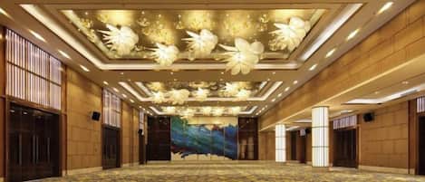 A large, well-lit conference room with a patterned carpet, a floral ceiling design, and a mural on the far wall.
