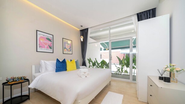 Camera da letto moderna con un letto, un comodino e vista sull'esterno.