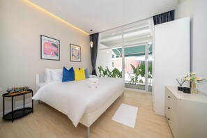 Une chambre moderne avec un lit, une table de chevet et une vue sur l’extérieur.