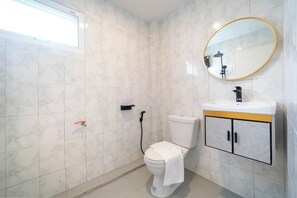 Une salle de bain avec des toilettes, un lavabo et un miroir.
