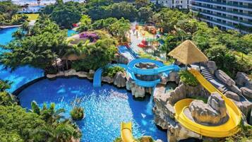 Un resort con una piscina grande, toboganes acuáticos y vista al mar.