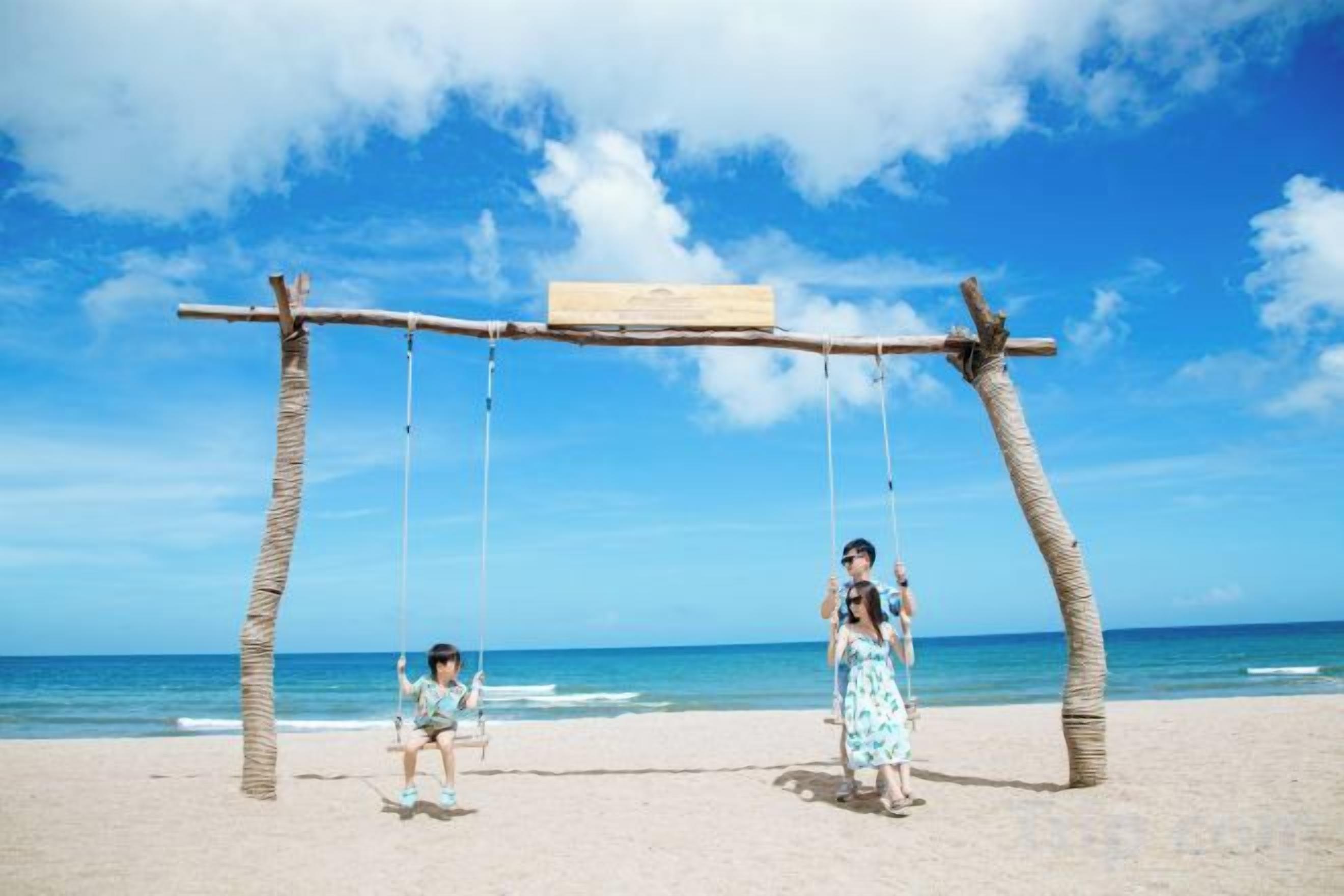 A beach with a swing set and a wooden structure.