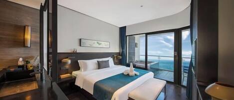 A modern hotel room with a large bed, a bedside table, a bench, a view of the ocean, and a balcony.