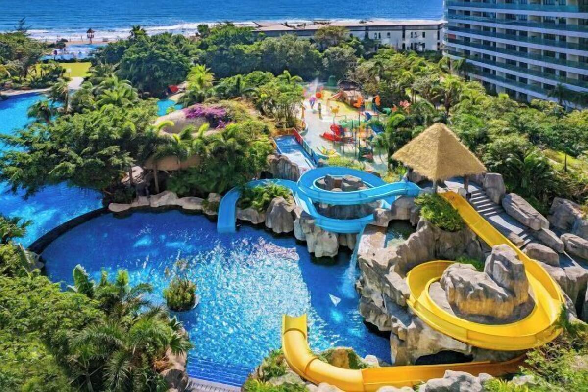 A resort with a pool, water slides, and a beach view.