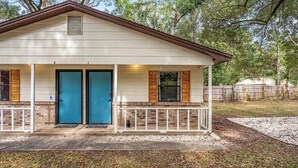 A single-story building with a porch, two doors, and a small covered area. - Cozy duplex w/fire pit & BBQ (Pensacola)