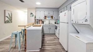 A compact kitchen with a central island, a sink, and a built-in washer and dryer. - Cozy duplex w/fire pit & BBQ (Pensacola)