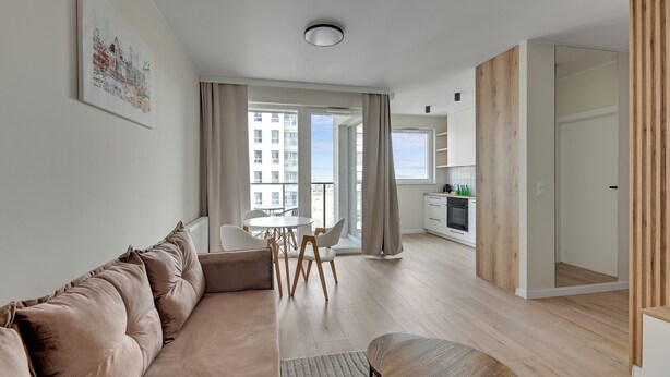 A modern living room with a sofa, a dining table with chairs, and a view of the cityscape through large windows. - Horizon 122 -SeaView by GrandApartments  (Gdansk)