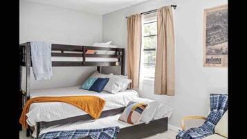 2 habitaciones, escritorio y tabla de planchar con plancha