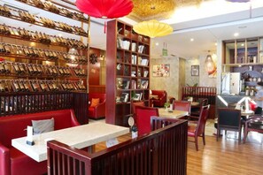 A restaurant with wooden furniture, a wine rack, and a bookshelf. - Kaiwei Hotel (Wanning High-speed Railway Station Branch) (Wanning)