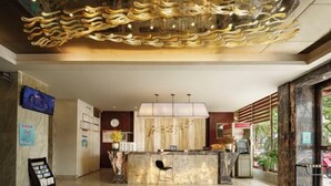 A modern reception area with a marble counter, a unique ceiling design, and a large window offering a view of the outdoors. - Kaiwei Hotel (Wanning High-speed Railway Station Branch) (Wanning)