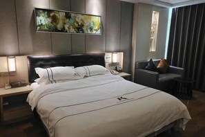 A hotel room with a large bed, bedside tables, a desk, and a window with curtains. - Kaiwei Hotel (Wanning High-speed Railway Station Branch) (Wanning)