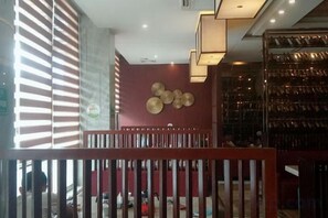 A hotel interior with a reception desk, a staircase, and a wall with circular decorations. - Kaiwei Hotel (Wanning High-speed Railway Station Branch) (Wanning)