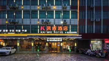 A hotel entrance with a sign reading 'KAI WEI HOTEL' and a contact number.
