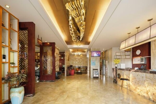 A hotel lobby with a reception desk, seating area, and decorative elements. - Kaiwei Hotel (Wanning High-speed Railway Station Branch) (Wanning)