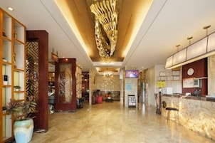 Eine Hotelhalle mit Empfangstresen, Sitzgelegenheiten und Dekorationselementen.