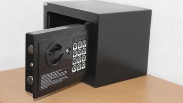 A black security keypad with a numeric keypad and a keyhole, mounted on a wooden surface.