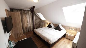 Un dormitorio con cama, mesitas de noche, televisión, ventana y una escalera.
