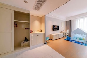 Une chambre d’hôtel avec un placard, une petite kitchenette, une télévision et une fenêtre donnant sur un beau paysage.