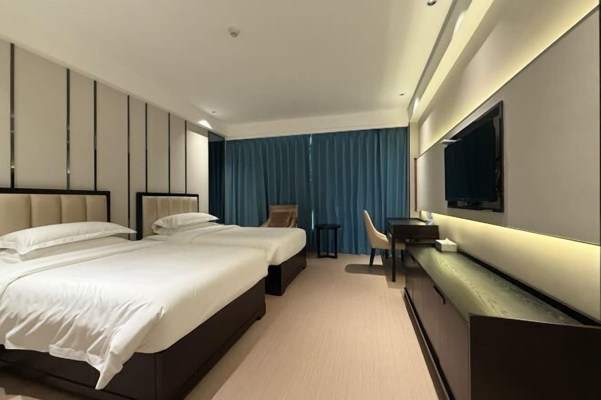 Een moderne hotelkamer met een groot bed, een bureau en een televisie.