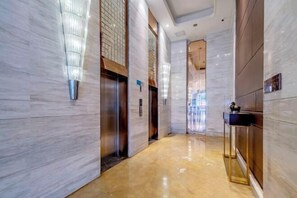 Eine moderne Hotelhalle mit Marmorwänden, einem polierten Boden und einer Rezeption.