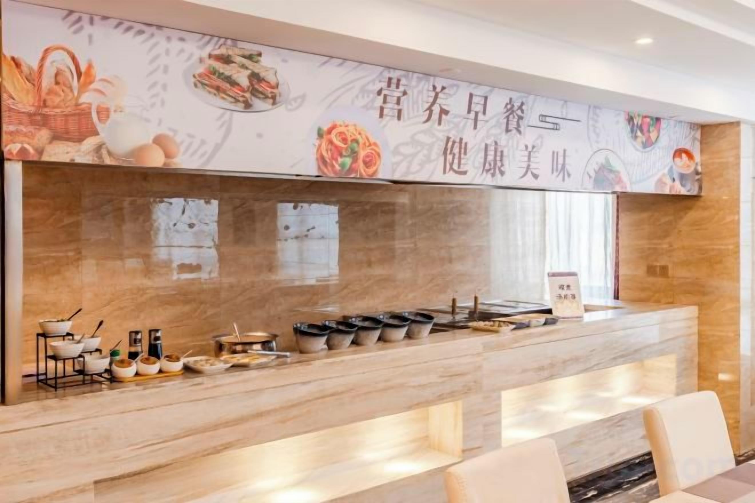 A reception area with a counter displaying various dishes and a signboard.