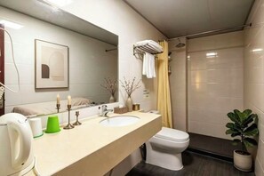 Een moderne badkamer met een grote spiegel, twee wastafels, een toilet en een douche.