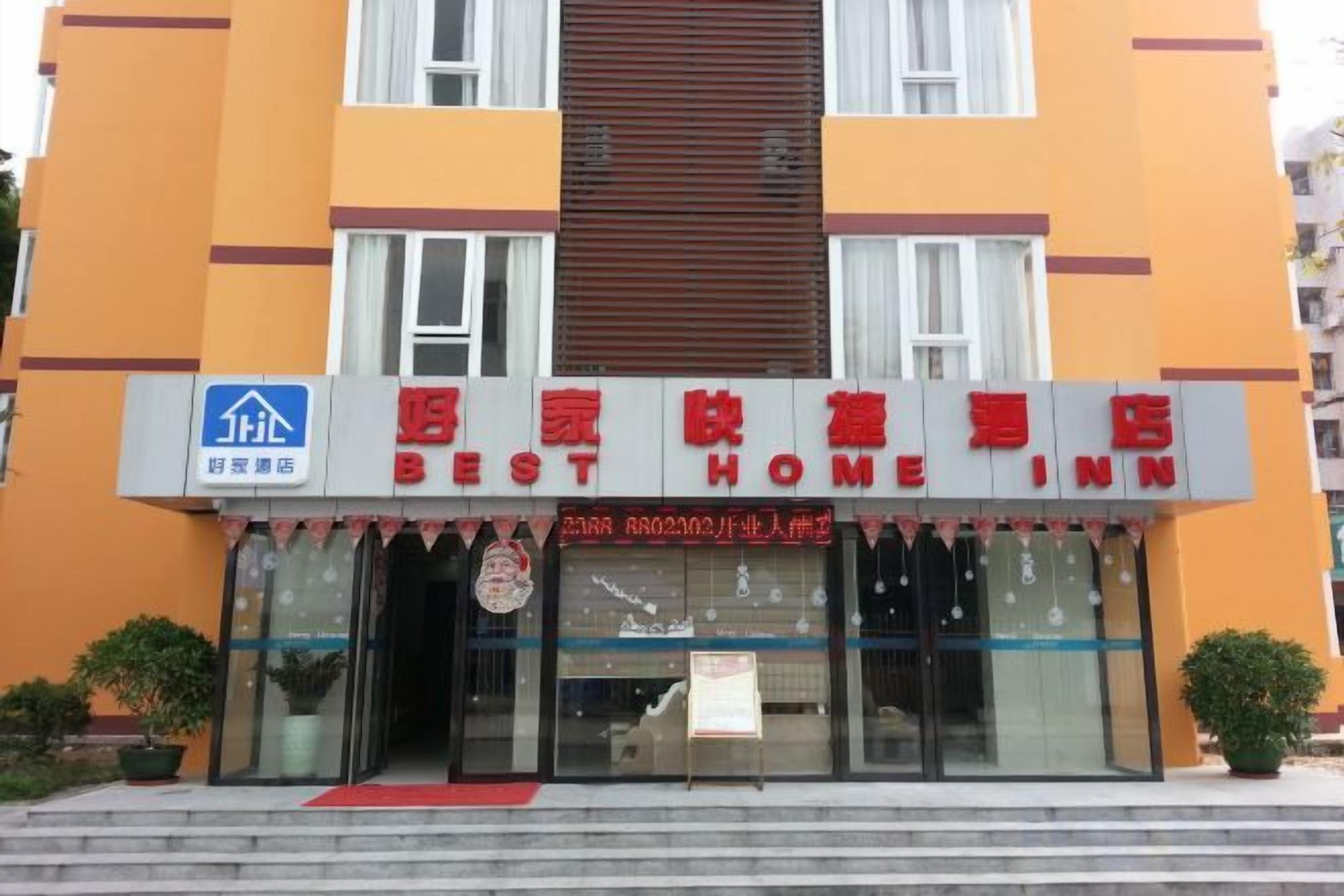 A hotel with a prominent 'Best Home Inn' sign, a visible entrance, and a small signboard with contact information.