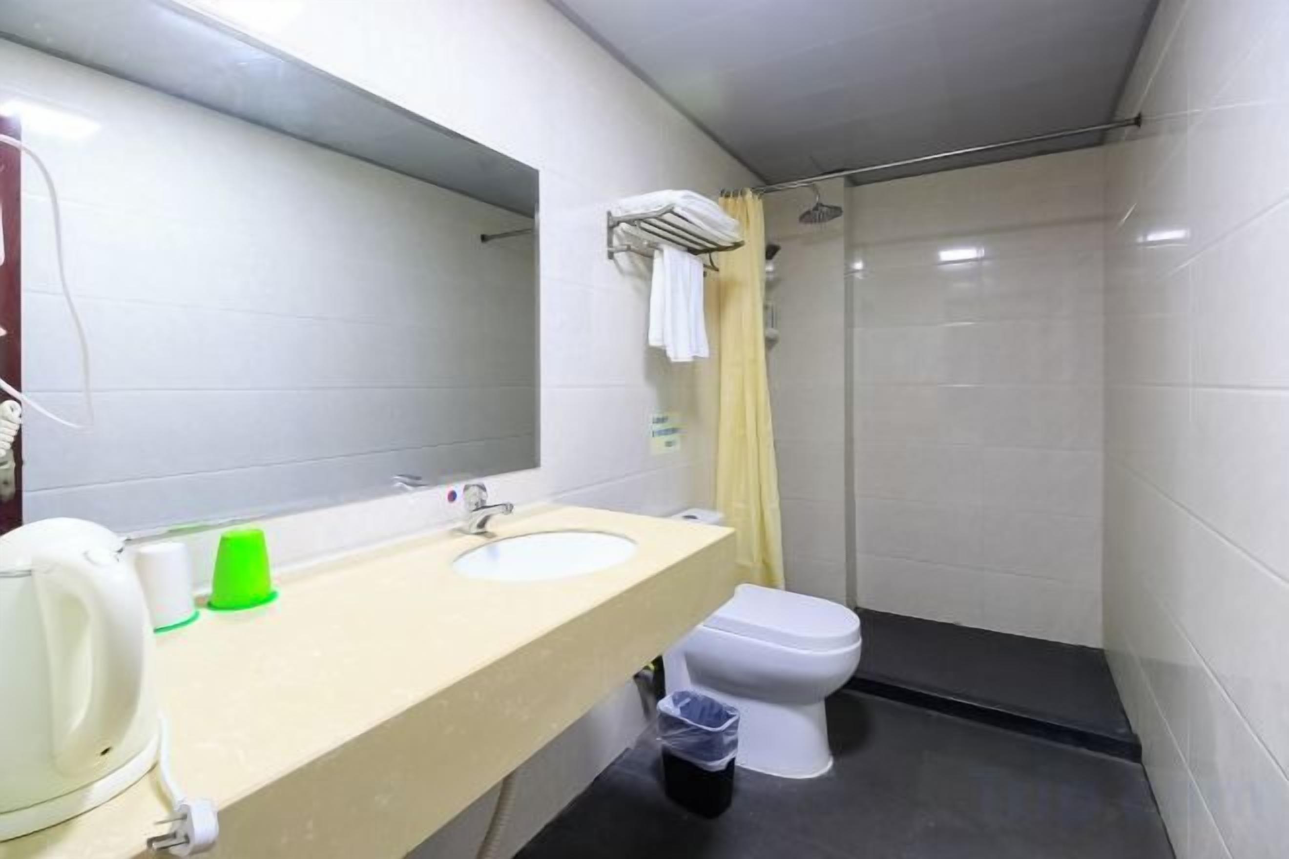 A bathroom with a sink, mirror, toilet, and shower.