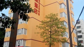 A multi-story building with a yellow facade and red signage.