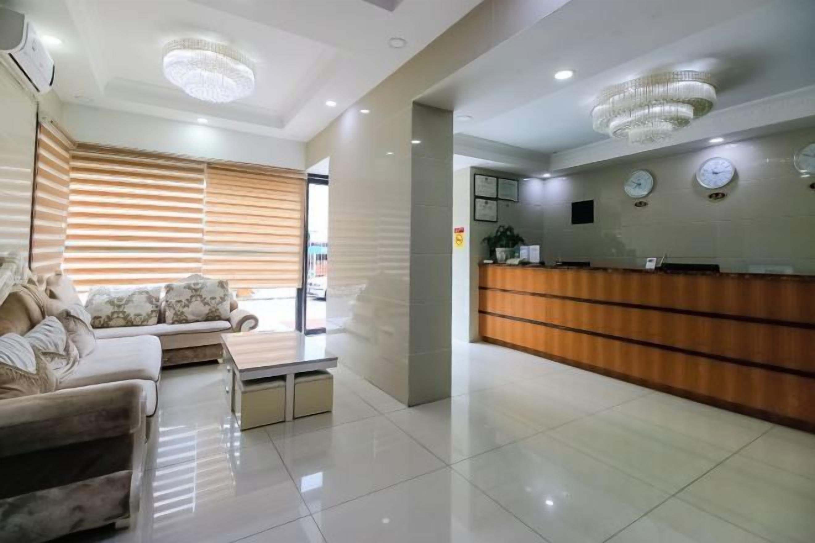 A modern reception area with a wooden reception desk, a sofa, and a coffee table.