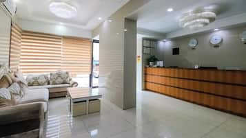 A modern reception area with a wooden reception desk, a sofa, and a coffee table.