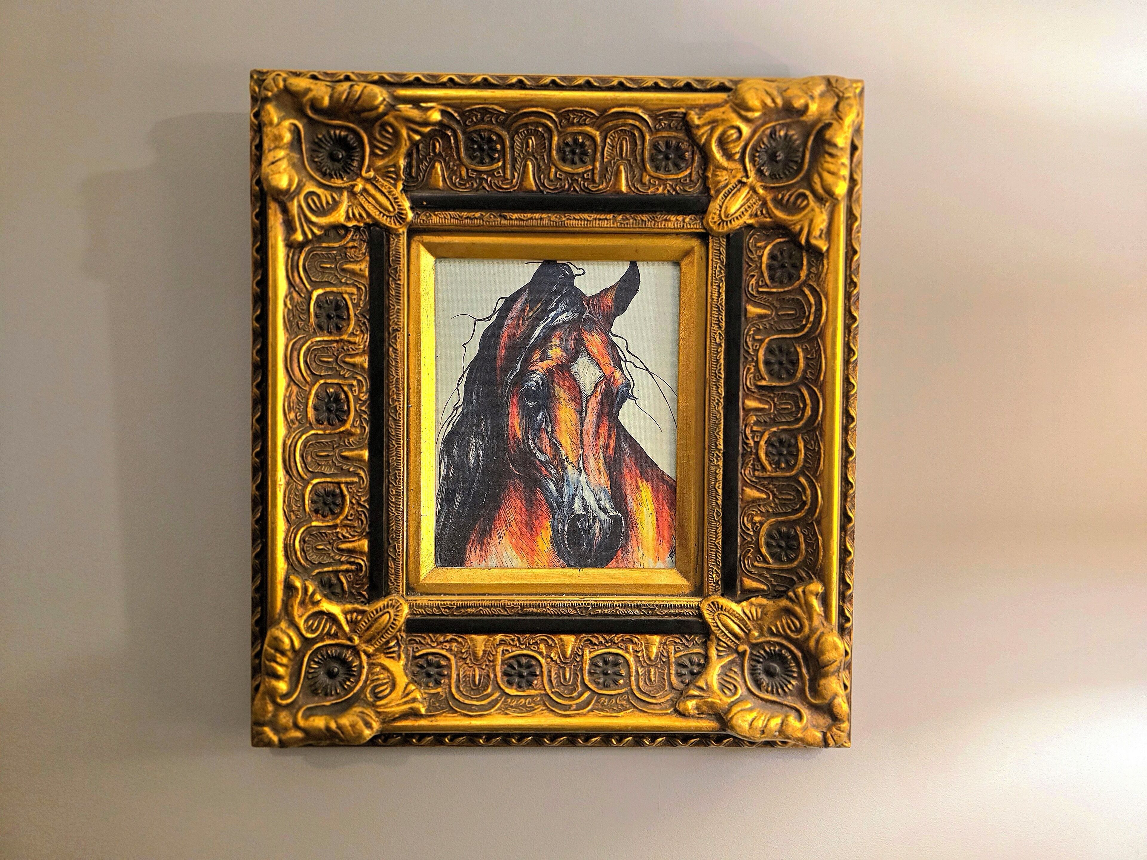 A framed artwork of a horse's head.