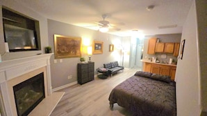A compact living space with a fireplace, a sofa, a bed, a dining area, and a kitchen. - The secret Manor (Durham)