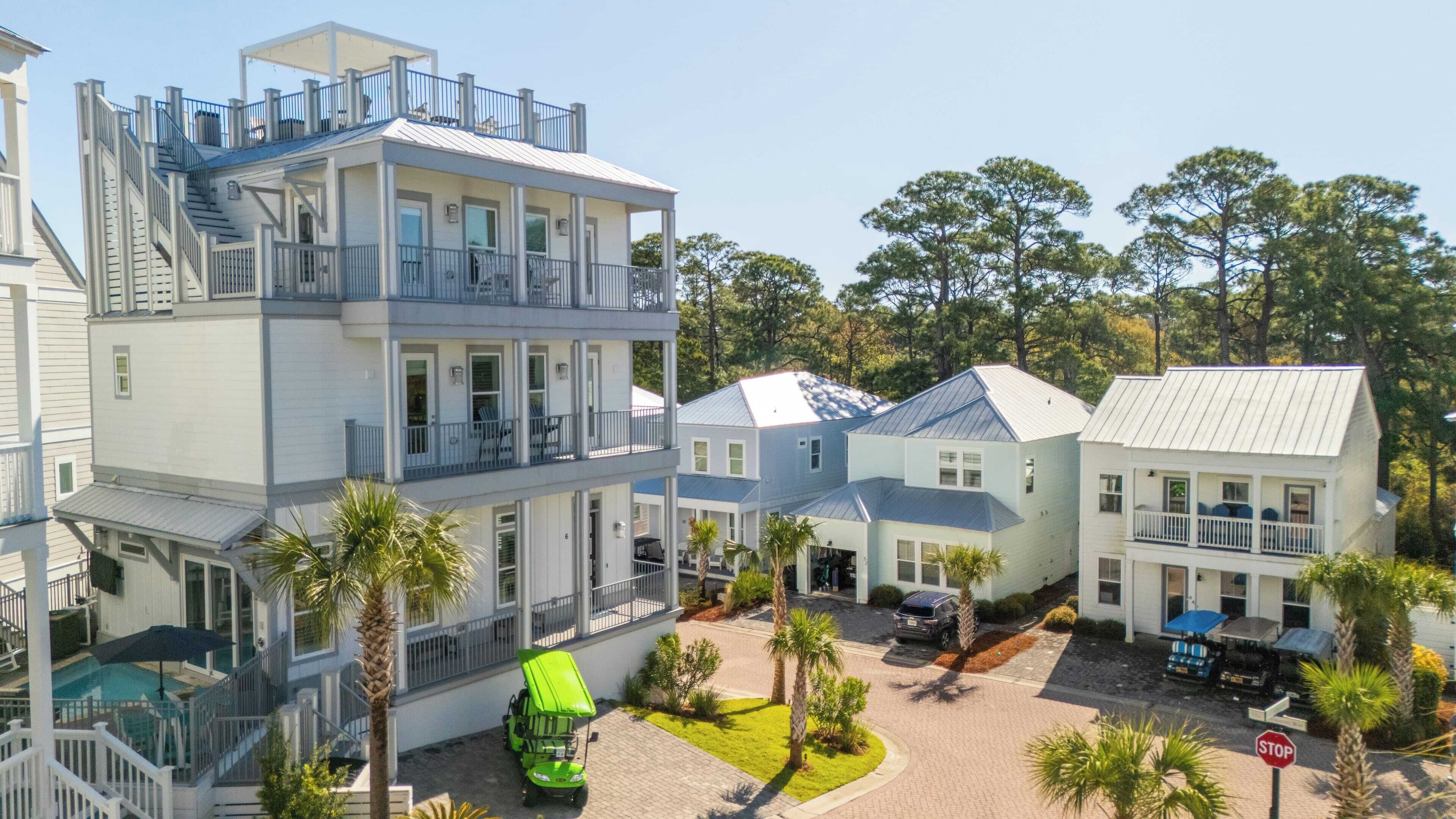 A multi-story hotel with balconies, a swimming pool, and a parking area.