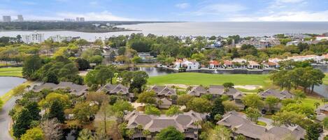 Zona residencial con casas, un campo de golf y una masa de agua.