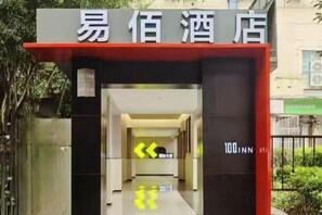 Entrada d'hotel amb un senyal que indica el nom i la direcció al vestíbul.