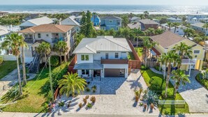 Un quartier résidentiel avec des maisons, des palmiers et une vue sur l’océan.
