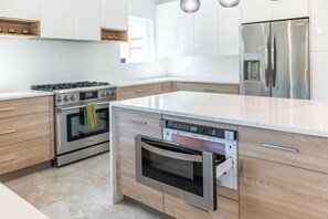 Enjoy cooking in this well-equipped kitchen with a refrigerator, dishwasher, and large island with a sink.
