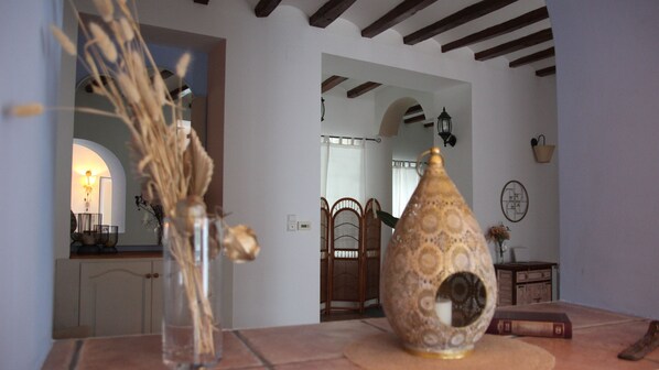 Una habitación con vista despejada a un comedor, un jarrón decorativo y una mesa de madera.
