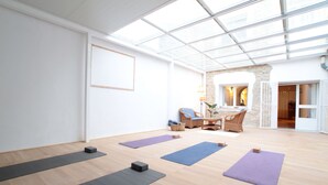 Ein geräumiges Zimmer mit Holzboden, Yogamatten und einer Glaskuppel.