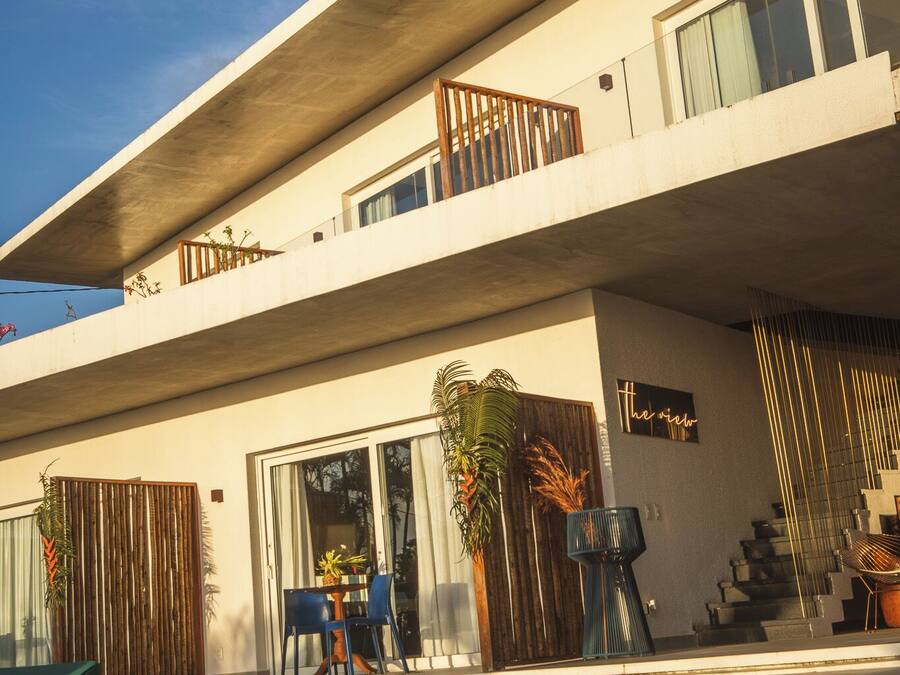 Un bâtiment moderne à deux étages, doté d’une piscine, d’un espace extérieur aménagé et d’une enseigne sur laquelle on peut lire : « la vue ».