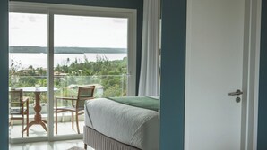 A bedroom with a large sliding glass door leading to a balcony with a table and chairs. - The View Pipa (Tibau do Sul)