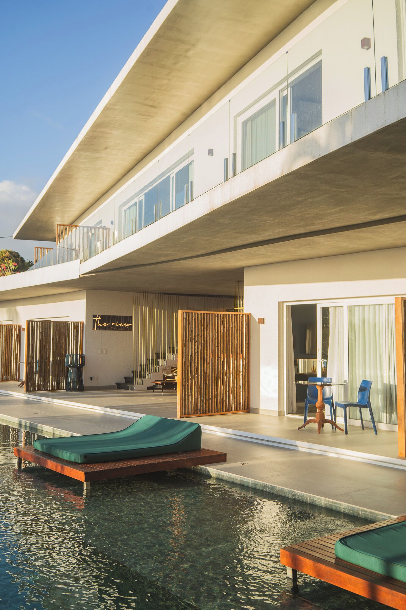 Un hôtel moderne doté d’une piscine, d’un espace extérieur aménagé et d’un balcon.