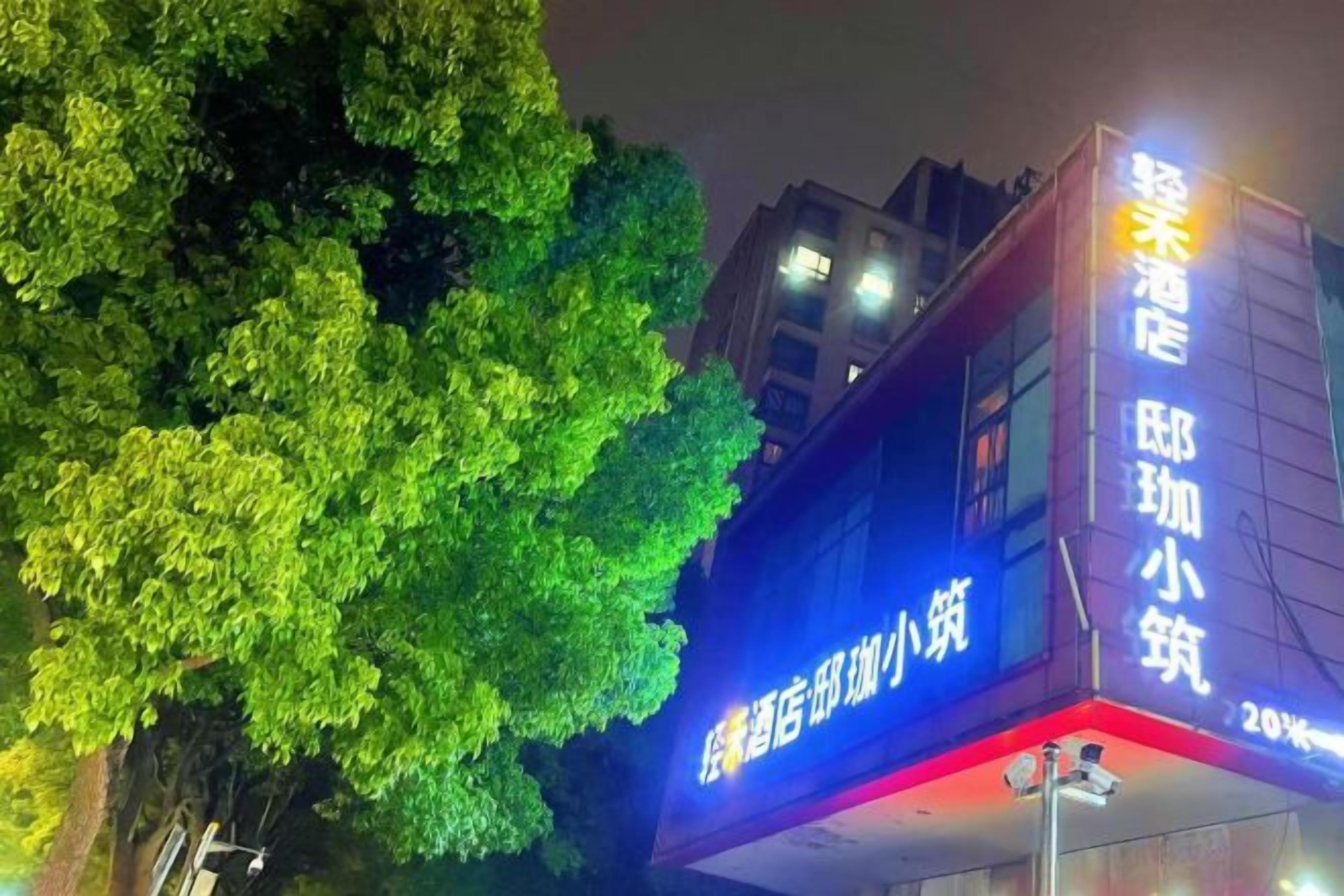 A building with illuminated signage indicating a hotel and a restaurant.