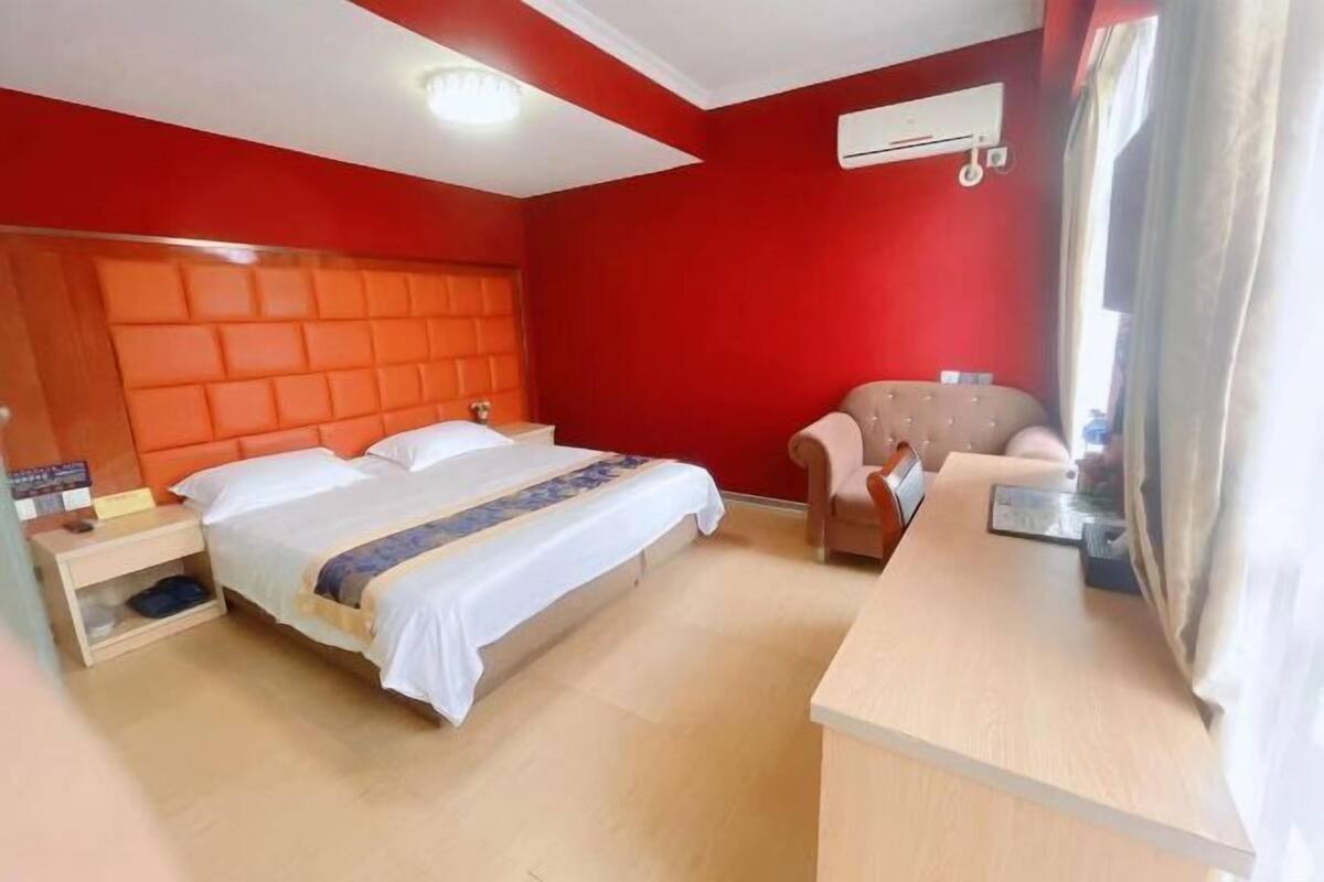 Una habitación de hotel con una cama grande, un escritorio y una silla.