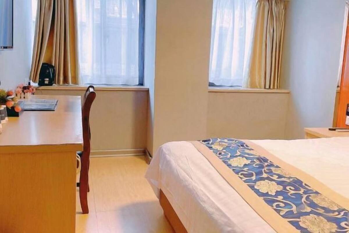 Una habitación de hotel con una cama, un escritorio y una silla.